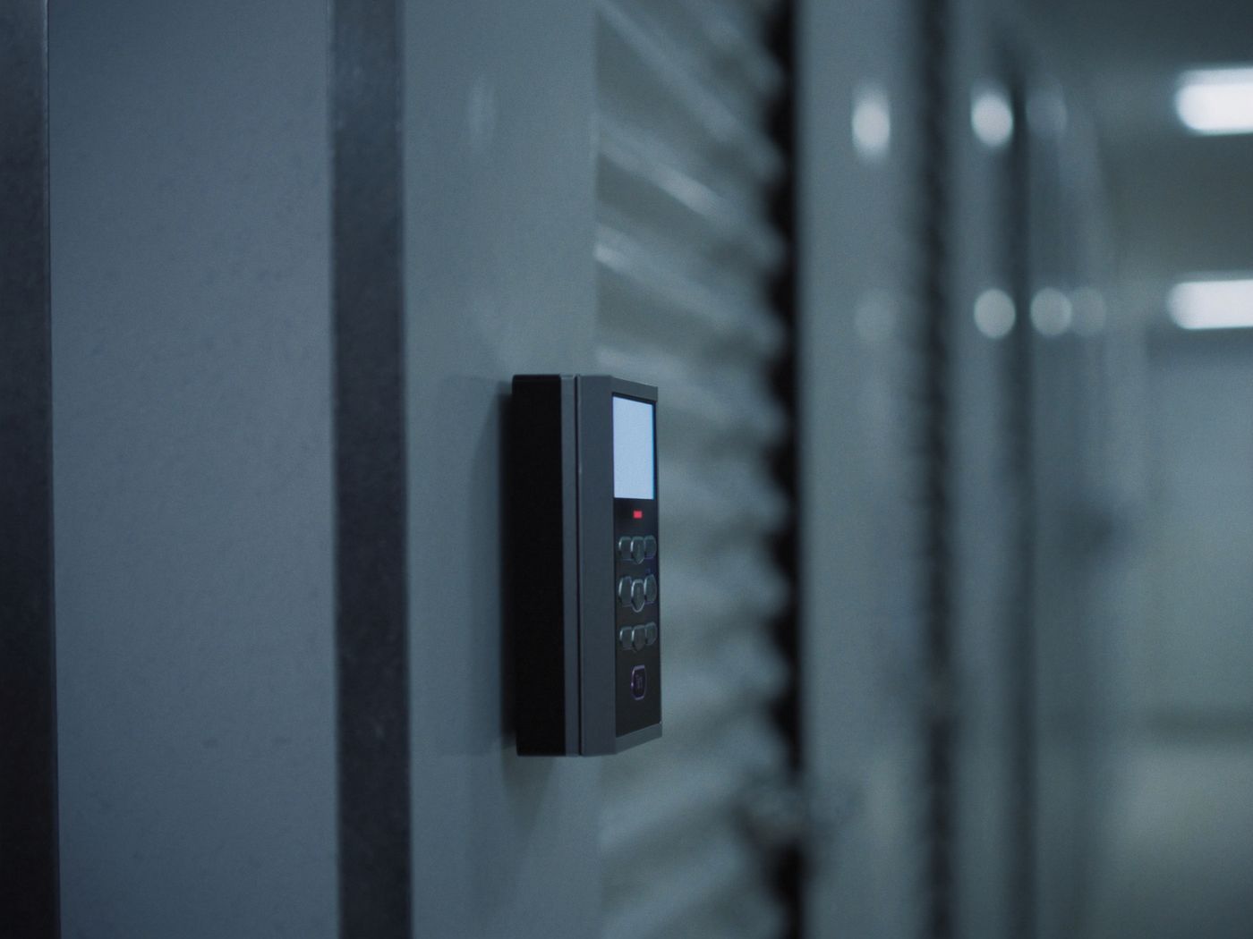 Electronic access-control reader mounted beside a storage unit door